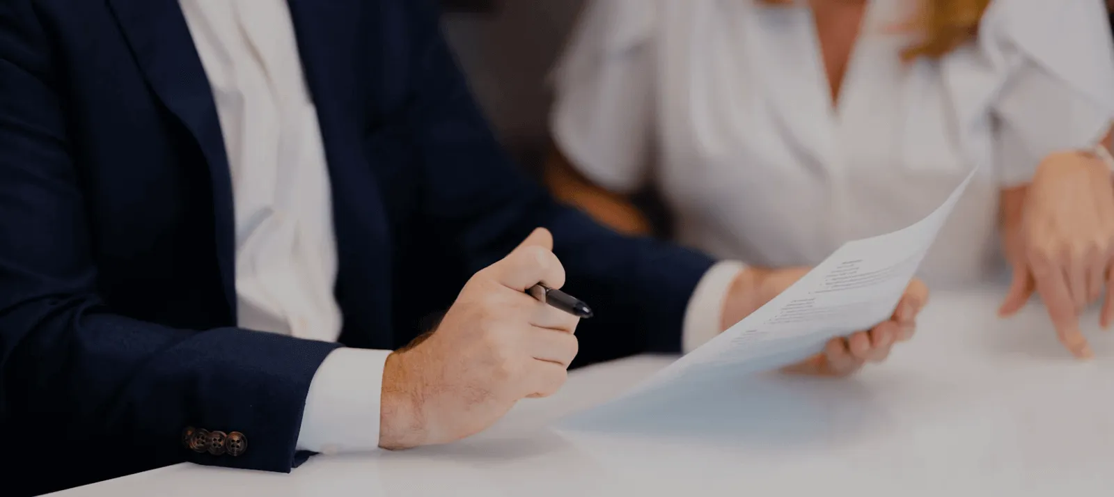 Two people reviewing a printed report at a desk
